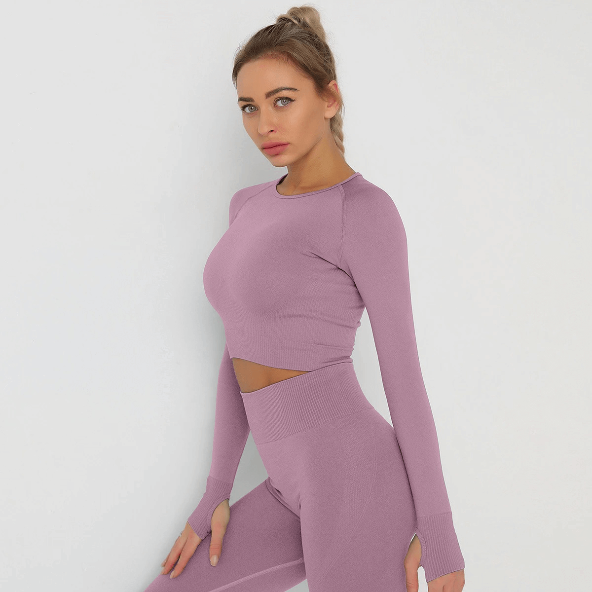 Model wearing a stylish long sleeve crop top in lavender, perfect for gym and yoga. Breathable, quick-dry fabric for active women.